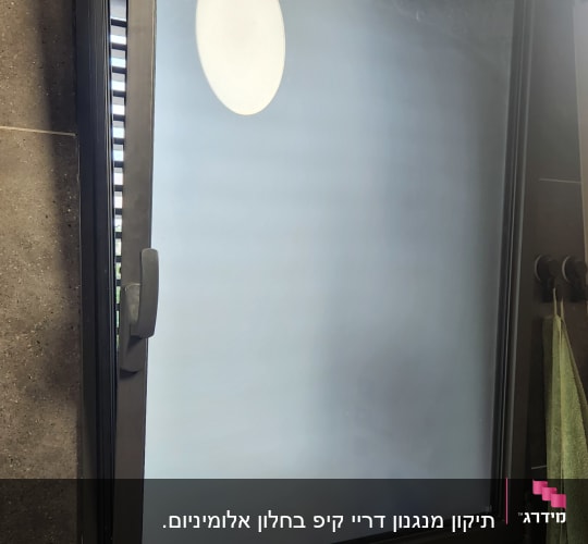 חלון פתוח עם מסגרת מתכת בחדר אמבטיה